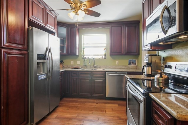 1311 Frenchmen St, New Orleans, LA 70116 - kitchen with stainless steel appliances, a sink, dark brown cabinets, ceiling fan, and wood-type flooring