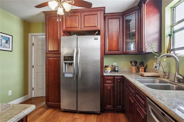 1311 Frenchmen St, New Orleans, LA 70116 - kitchen with stainless steel appliances, a sink, ceiling fan, and reddish brown cabinets