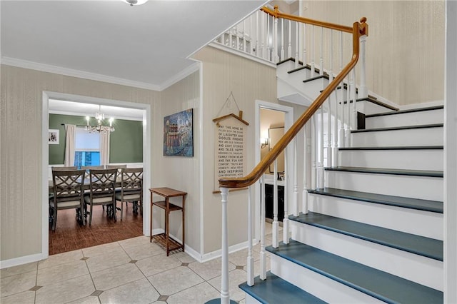 staircase with tile patterned floors, ornamental molding, and a chandelier