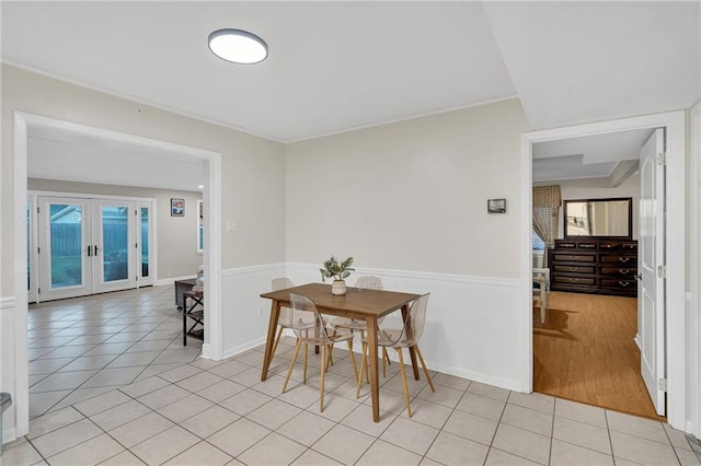 dining room with french doors and light hardwood / wood-style floors