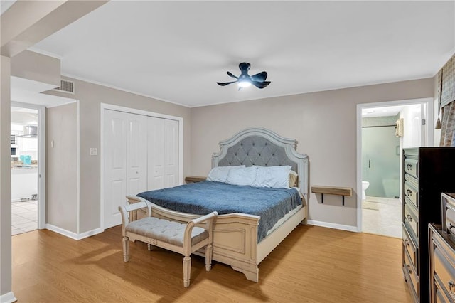 bedroom featuring ceiling fan, a closet, light wood-type flooring, and ensuite bath