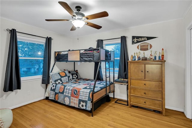 bedroom with ceiling fan, wood-type flooring, and ornamental molding