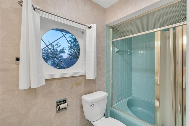 bathroom with toilet and tiled shower / bath