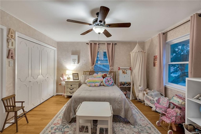 bedroom featuring ceiling fan, a closet, and hardwood / wood-style flooring