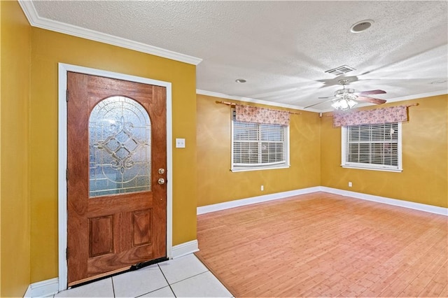 entrance foyer with a textured ceiling, light wood-type flooring, ceiling fan, and crown molding