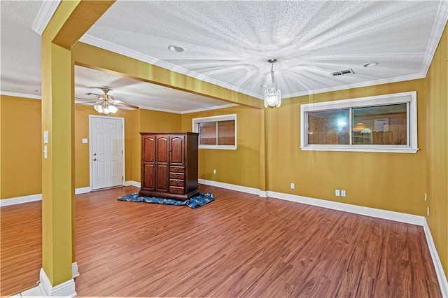 exercise room featuring a textured ceiling, hardwood / wood-style flooring, ceiling fan, and ornamental molding