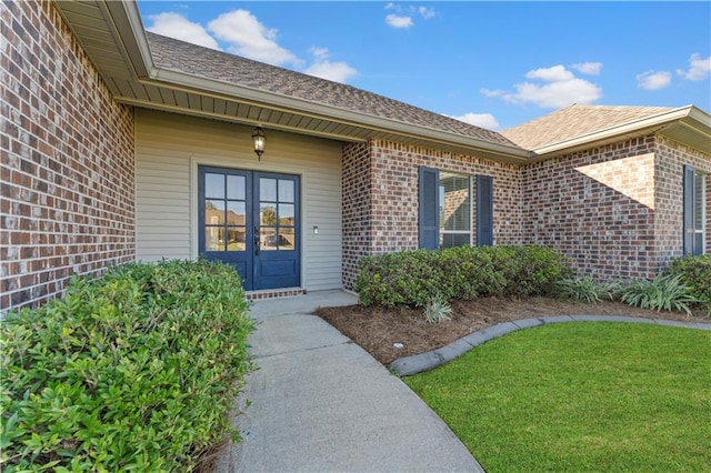 doorway to property featuring a lawn and french doors