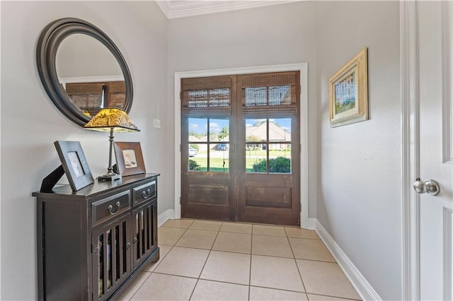 foyer featuring french doors, light tile patterned floors, and ornamental molding