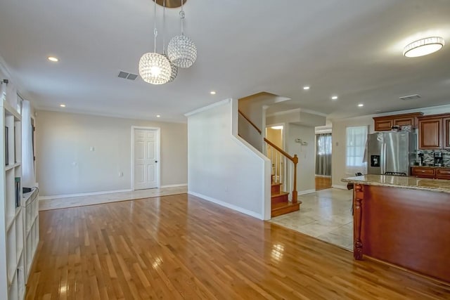 kitchen with decorative light fixtures, light hardwood / wood-style floors, decorative backsplash, and stainless steel fridge with ice dispenser