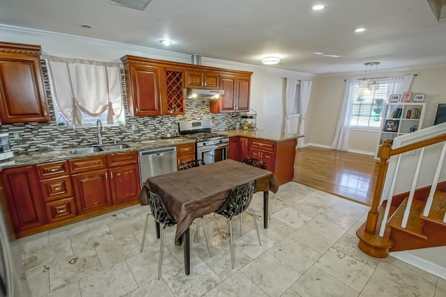 kitchen with pendant lighting, backsplash, sink, ornamental molding, and appliances with stainless steel finishes