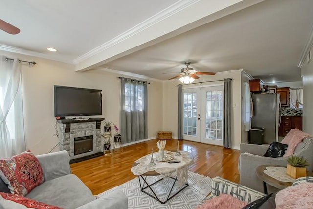 living room featuring beam ceiling, crown molding, french doors, and light hardwood / wood-style floors