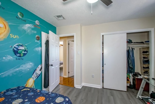 4520 Alphonse St, Metairie, LA 70006 - bedroom with wood finished floors, a textured ceiling, a ceiling fan, a closet, and baseboards