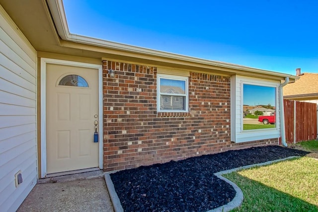 view of exterior entry featuring a yard