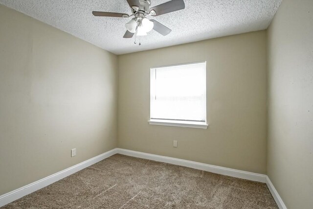 unfurnished room featuring light carpet and a textured ceiling