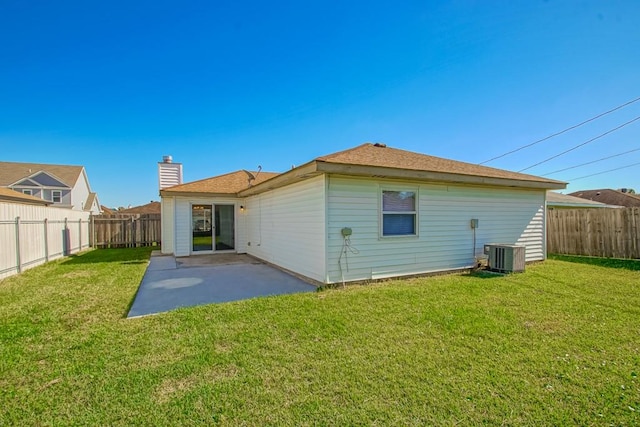 rear view of house with central AC, a yard, and a patio