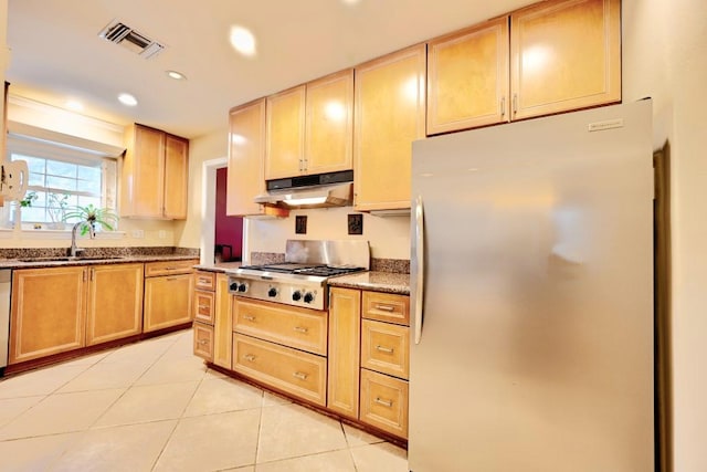 kitchen featuring light brown cabinetry, sink, light tile patterned floors, and stainless steel appliances