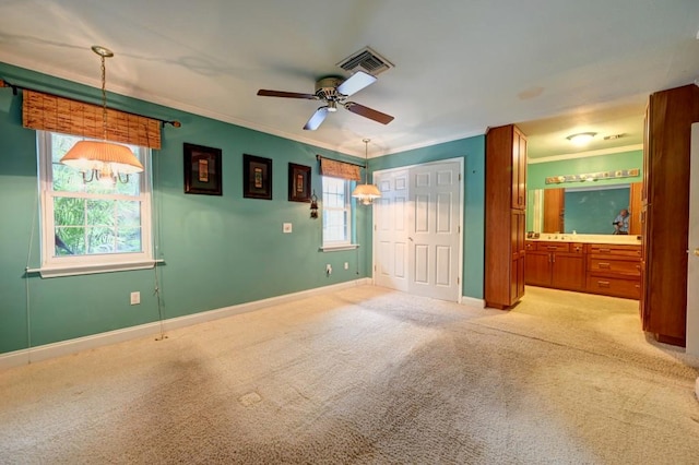 unfurnished bedroom with carpet, ceiling fan, ornamental molding, and ensuite bathroom