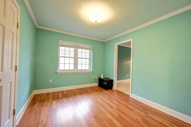 spare room with light hardwood / wood-style floors and ornamental molding