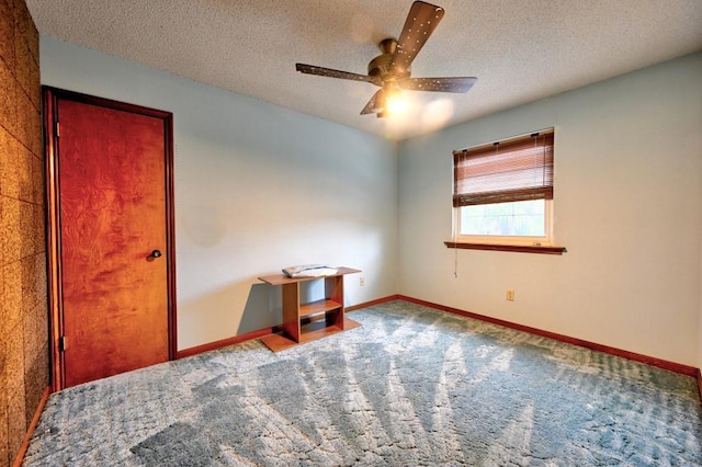 carpeted empty room with ceiling fan and a textured ceiling