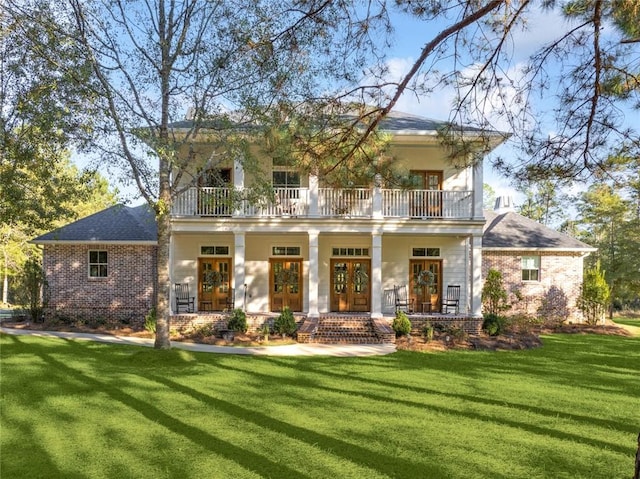 view of front of home featuring a porch, a balcony, a front lawn, and french doors