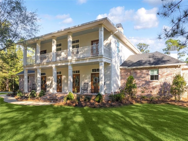 view of front of property with a balcony, a front lawn, and covered porch