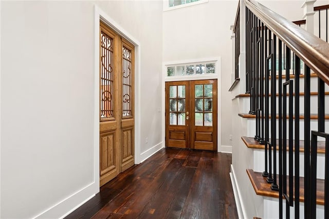 entryway with dark hardwood / wood-style flooring, french doors, and a towering ceiling