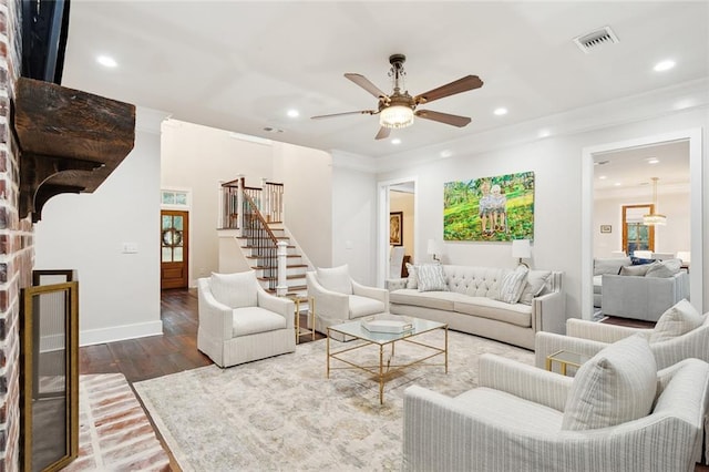 living room featuring a fireplace, ceiling fan, hardwood / wood-style floors, and crown molding