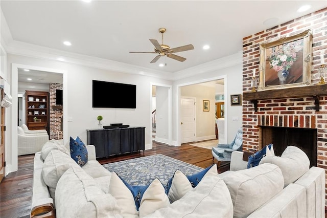 living room with ceiling fan, a fireplace, dark wood-type flooring, and ornamental molding