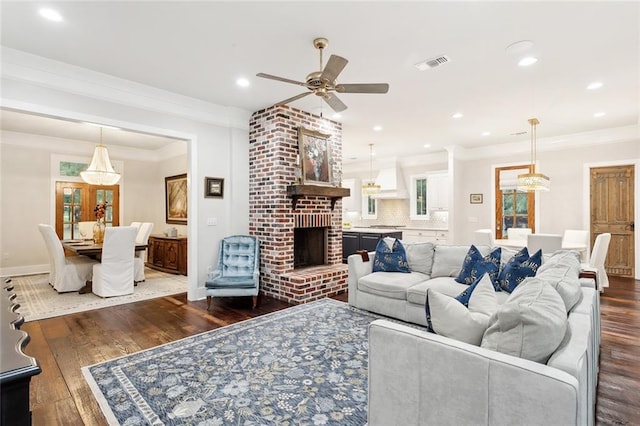 living room with ceiling fan, a fireplace, crown molding, and dark hardwood / wood-style floors