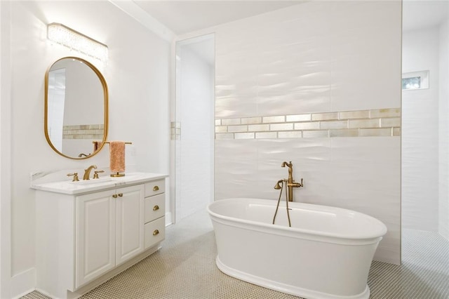 bathroom with tile patterned floors, vanity, a bath, and tile walls