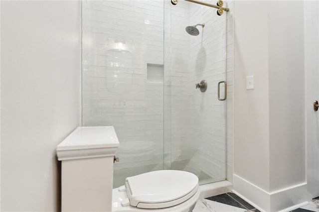 bathroom featuring toilet and a shower with door