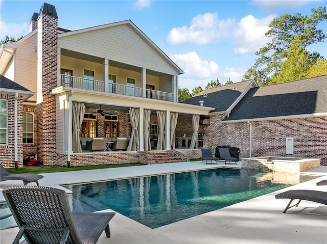 rear view of house with a patio area, ceiling fan, and a balcony