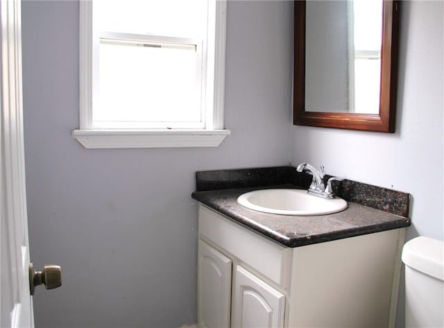 bathroom with vanity, toilet, and a wealth of natural light