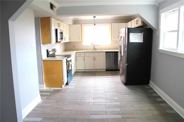 kitchen with crown molding, a healthy amount of sunlight, sink, and stainless steel appliances