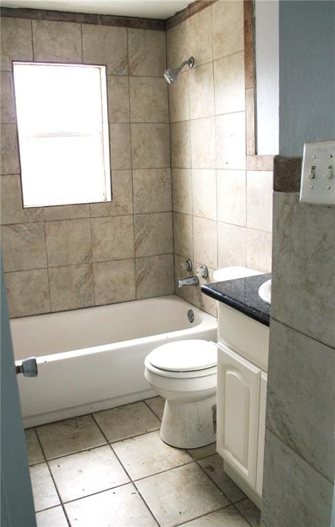 full bathroom featuring tile patterned flooring, vanity, toilet, and tiled shower / bath