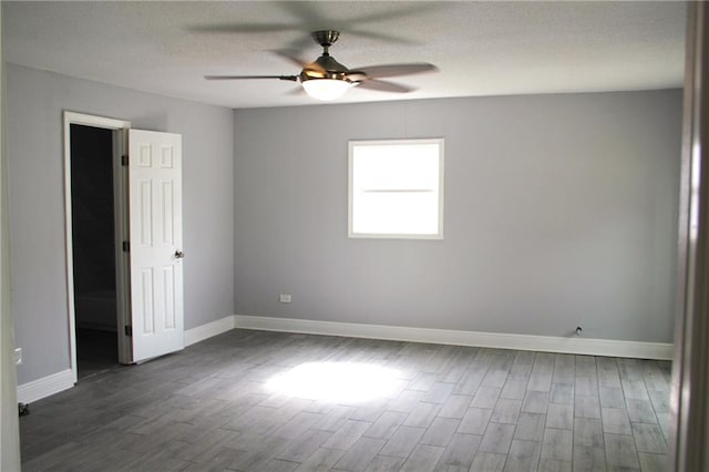 empty room featuring a textured ceiling, ceiling fan, and dark wood-type flooring