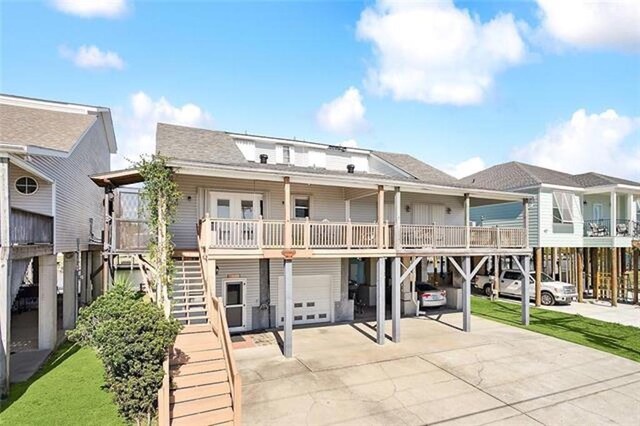 180 Lakeview Dr Unit A, Slidell, LA 70458 - back of property with driveway, a garage, stairs, roof with shingles, and a carport