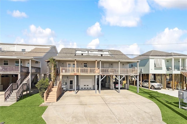 180 Lakeview Dr Unit A, Slidell, LA 70458 - rear view of house with a garage, stairway, concrete driveway, a yard, and roof with shingles