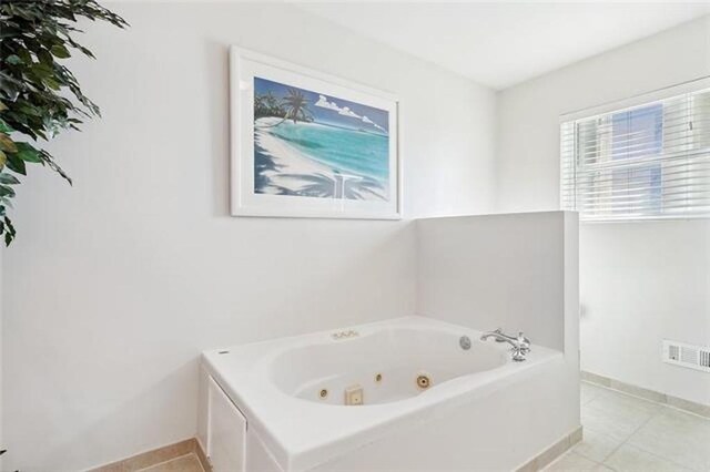 180 Lakeview Dr Unit A, Slidell, LA 70458 - full bathroom with a jetted tub, tile patterned flooring, and baseboards
