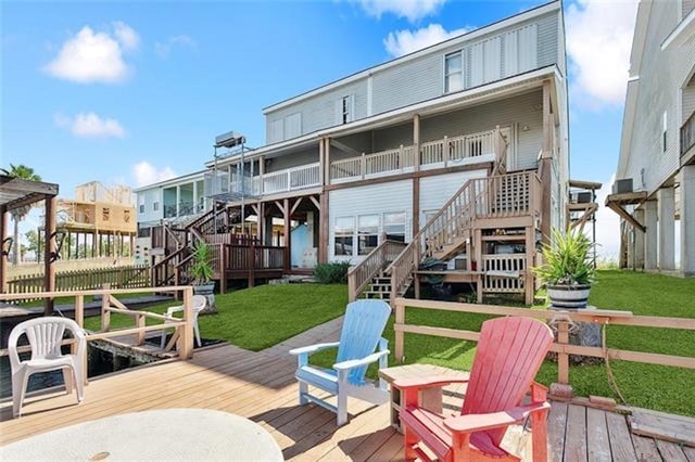 rear view of property featuring a deck and a yard