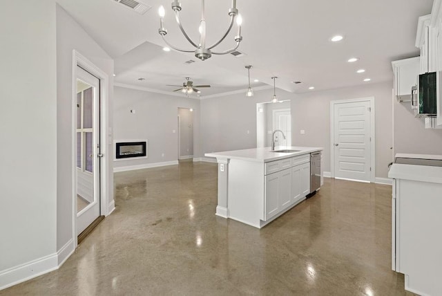 kitchen featuring appliances with stainless steel finishes, sink, white cabinetry, hanging light fixtures, and an island with sink