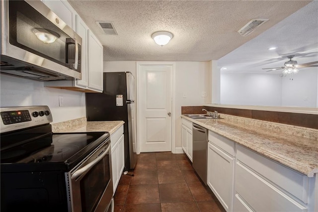 kitchen featuring stainless steel appliances, a sink, visible vents, and white cabinetry