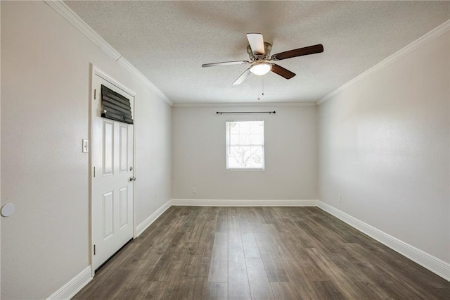 spare room with crown molding, a textured ceiling, baseboards, and dark wood-type flooring