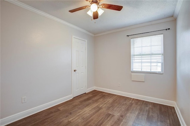 unfurnished room featuring ornamental molding, a textured ceiling, baseboards, and wood finished floors