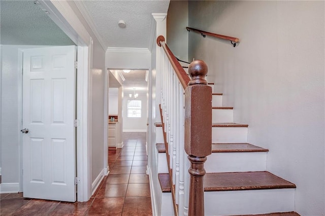 stairs featuring baseboards, tile patterned flooring, ornamental molding, and a textured ceiling