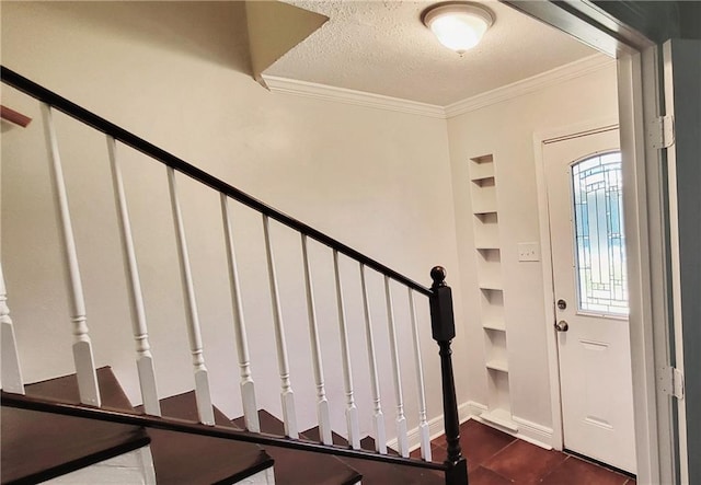 entryway with ornamental molding, stairway, a textured ceiling, and baseboards