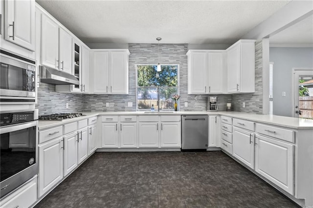 kitchen featuring pendant lighting, stainless steel appliances, white cabinetry, and a healthy amount of sunlight