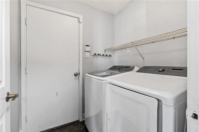 laundry area with washing machine and clothes dryer, laundry area, and a textured ceiling