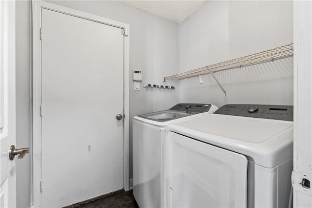 washroom featuring a textured ceiling and washing machine and clothes dryer