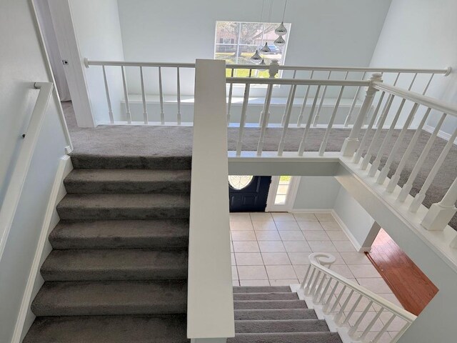 staircase with tile patterned flooring and baseboards